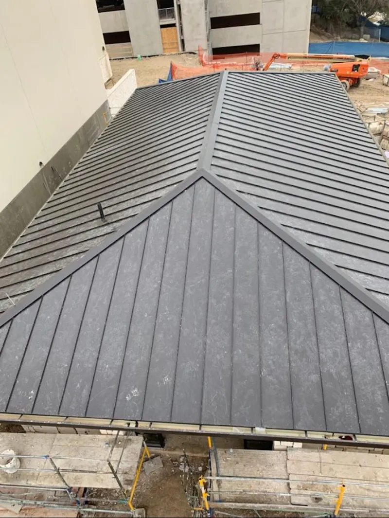 Commercial metal roof construction with crane equipment in Pittsboro